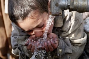 child drinking water from a pipe